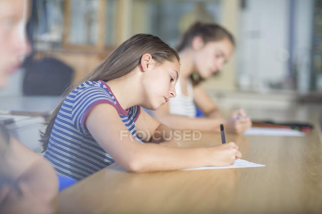 Female students writing during class test — Stock Photo
