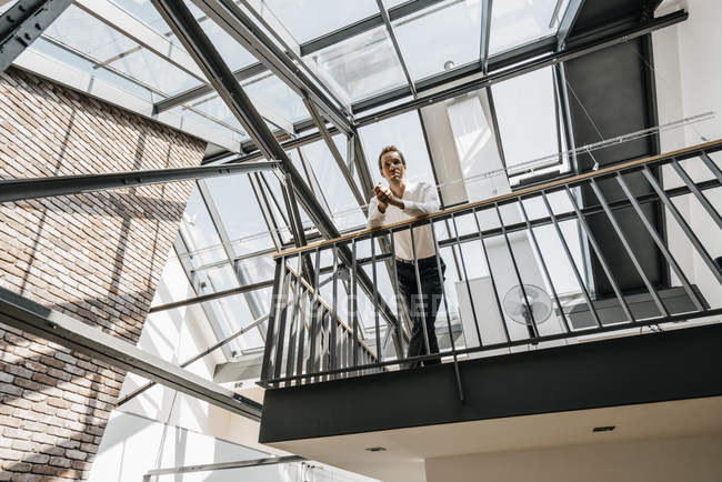 Geschäftsmann steht im Obergeschoss im Büro — Stockfoto