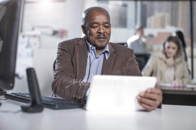 Uomo d'affari su tablet digitale in ufficio — Foto stock