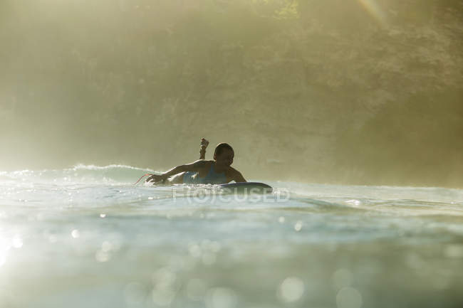 Indonesia, Bali, donna sdraiata sulla tavola da surf in mare — Foto stock