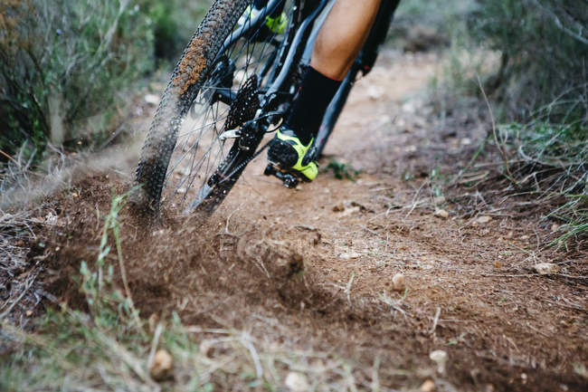 Close-up of mountainbiker skidding in a curve — Stock Photo