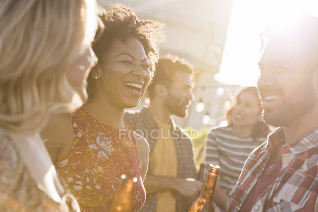 Amici alla festa sul tetto in giorno di sole lucente — Foto stock