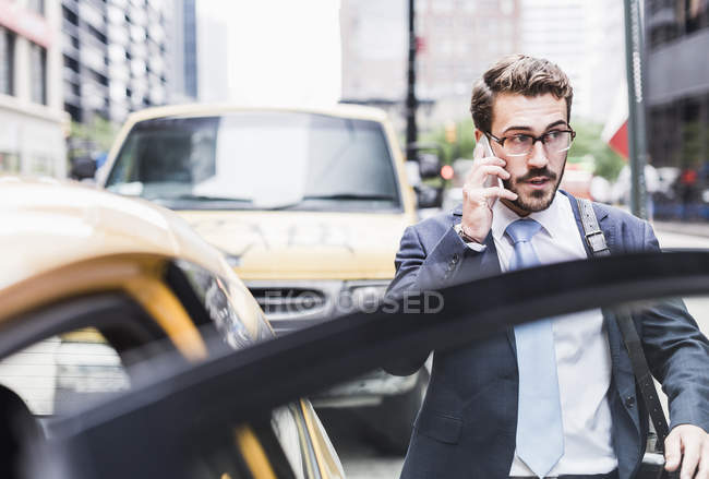 Geschäftsmann am Handy Betreten eines Taxis in Manhattan, New York City, USA — Stockfoto