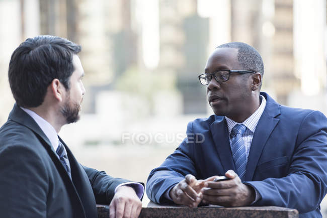 Two confident businessmen talking outdoors — Stock Photo