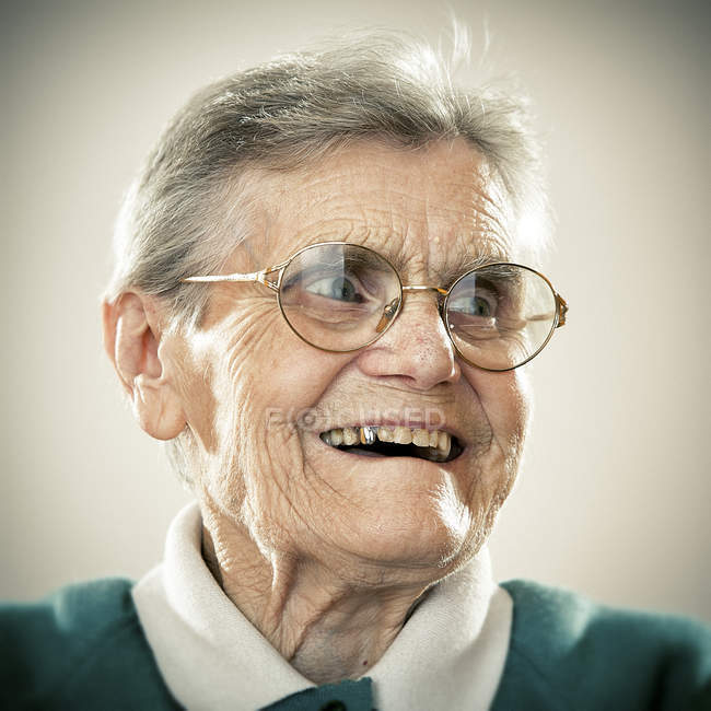 Портрет улыбающейся пожилой женщины, смотрящей в сторону — стоковое фото