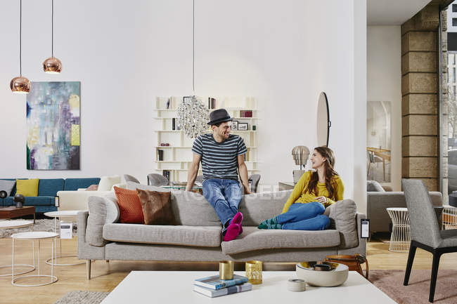 Retrato de pareja sentada en sofá en tienda de muebles - foto de stock