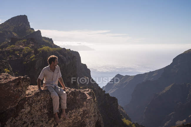 Spanien, Teneriffa, Tenorgebirge, Masca, Mann sitzt auf der Klippe — Stockfoto