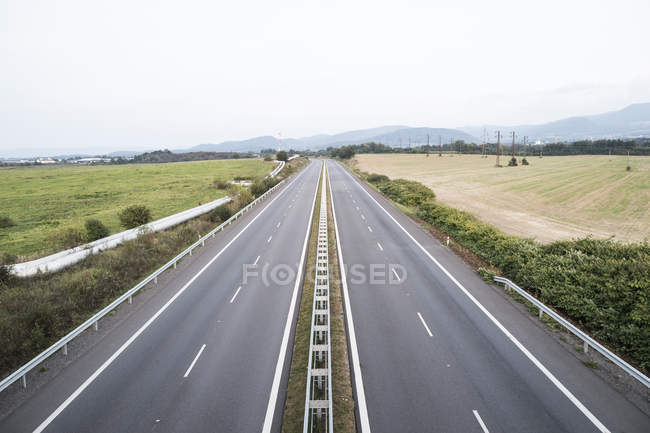 Autopista vacía y campos verdes paisaje - foto de stock
