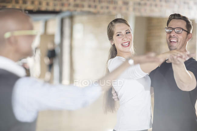 Lächelnde Tanzpartner gemeinsam im Tanzkurs mit Ausbilderin — Stockfoto