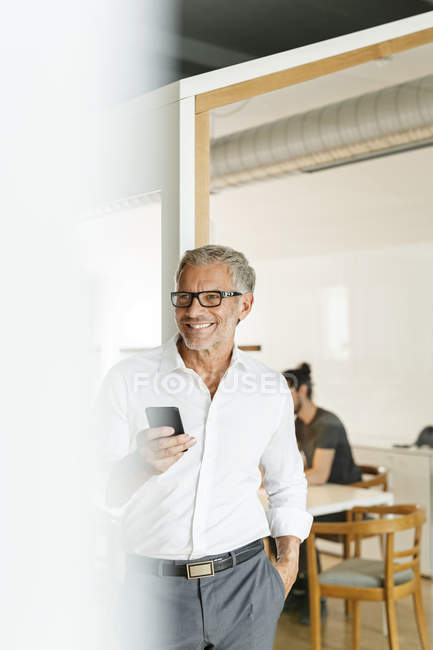 Geschäftsmann mit Handy im Büro — Stockfoto