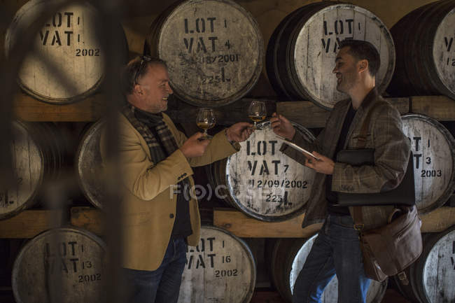Deux hommes confiants dégustation de whisky en distillerie — Photo de stock