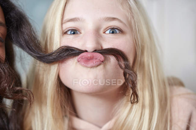 Porträt eines lächelnden Mädchens, das mit den Haaren ihres Freundes spielt — Stockfoto