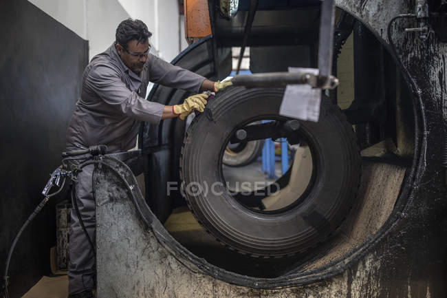 Чоловічий ремонтник працює над шин на заводі — стокове фото