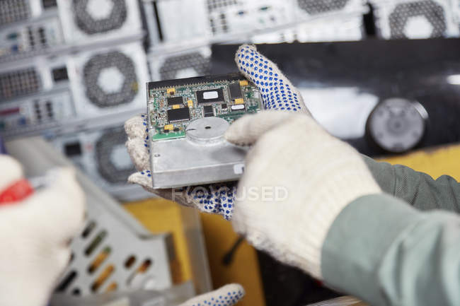 Lavoratore che tiene il disco rigido nell'impianto di riciclaggio del computer — Foto stock