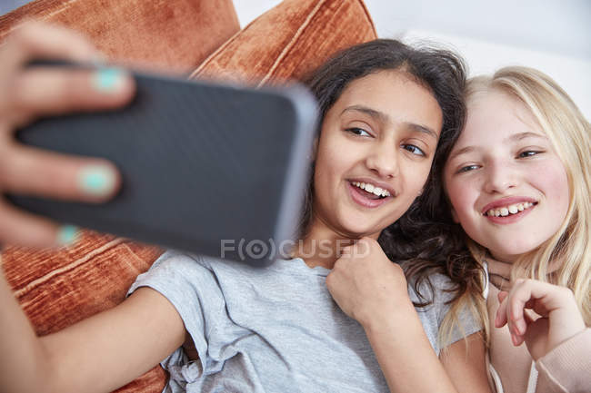 Due ragazze che ridono guardando smartphone insieme — Foto stock