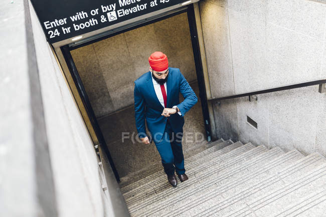 Indischer Geschäftsmann, der auf Treppen geht und auf Uhren in manhattan, ny, usa schaut — Stockfoto