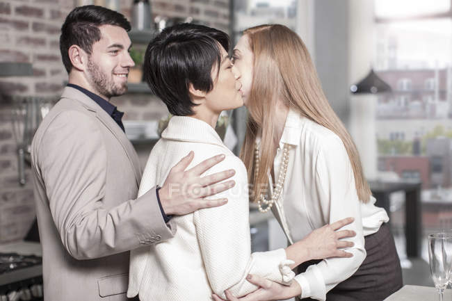 Couple greeting friend at modern apartment — Stock Photo