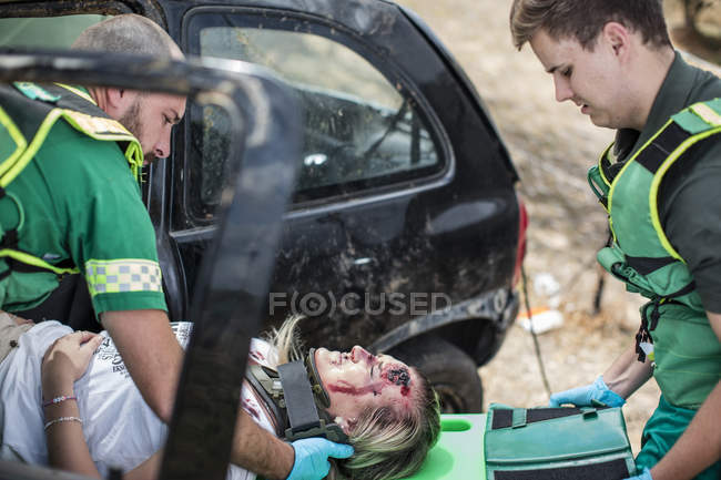 Les ambulanciers déplacent la victime de l'accident de voiture sur civière — Photo de stock