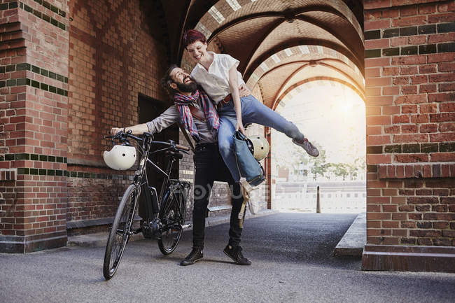 Portrait d'un cycliste souriant tenant une femme — Photo de stock