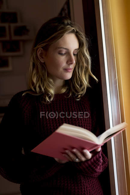 Жінка читає книжку вдома. — стокове фото