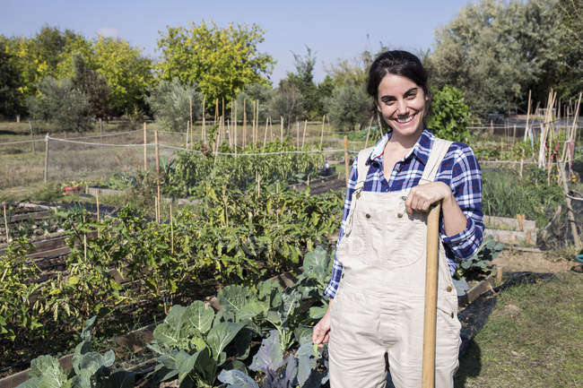 Smiling Female Gardener Standing On Farm And Looking At Camera Smiling Female Gardener Standing On Farm And Looking At Camera Stock Photo