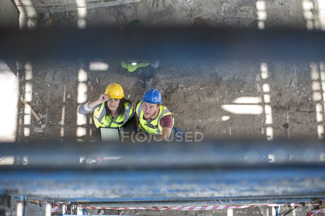 Bauarbeiter spricht Frau auf einer Baustelle an, Blick über den Kopf — Stockfoto
