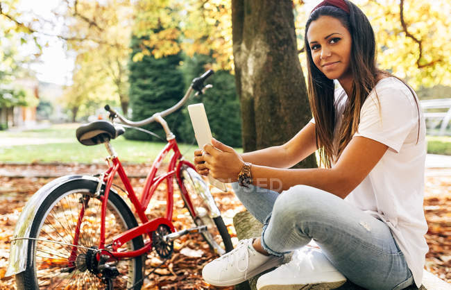 Jovem mulher usando tablet no parque — Fotografia de Stock
