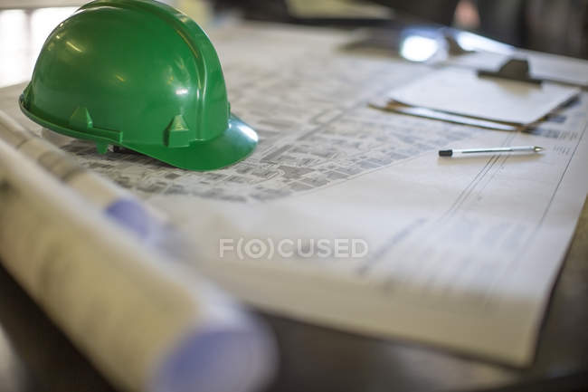Construction helmet on blueprints in site office — Stock Photo