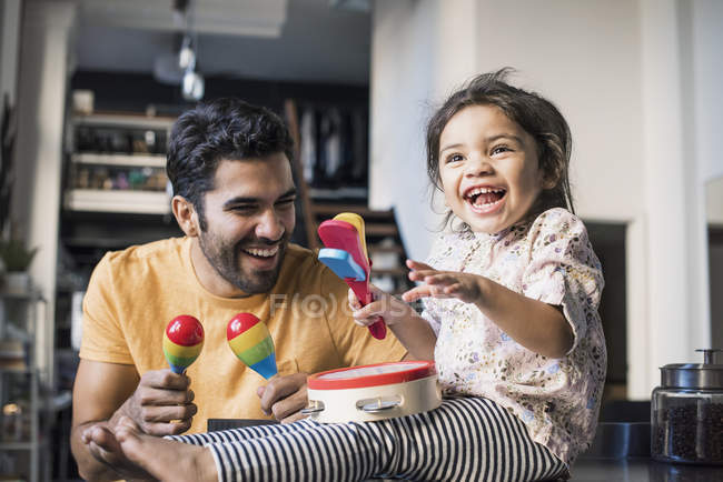 Vater und Tochter musizieren auf Spielzeug-Musikinstrumenten — Stockfoto