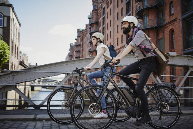 Portrait latéral de couple à vélo sur le pont — Photo de stock
