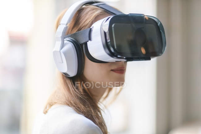Femme portant des lunettes de réalité virtuelle et écouteurs — Photo de stock