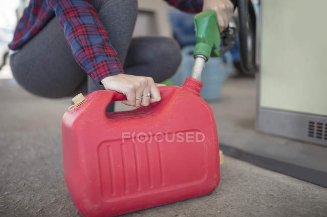 Woman filling up canister at fuel station — Stock Photo