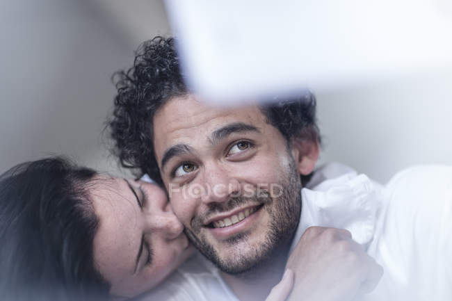 Счастливая пара вместе в постели, поцелуи и использование цифрового планшета — стоковое фото
