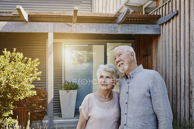 Premurosa coppia anziana in piedi di fronte alla casa — Foto stock
