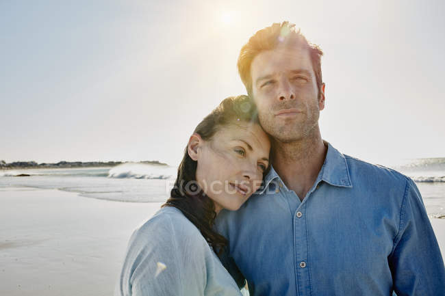 Ritratto di sorridente coppia di metà adulti in piedi sulla spiaggia — Foto stock