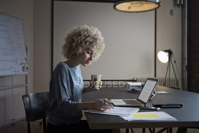 Frau arbeitet im Büro an Laptop und Dokumenten — Stockfoto