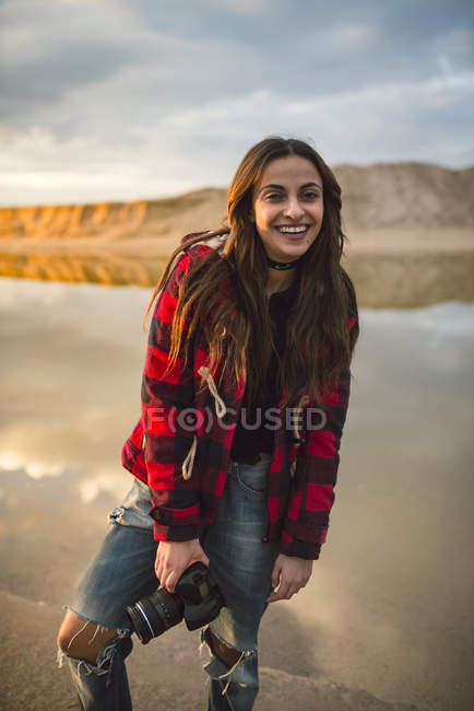 Молода жінка з дзеркальна камера на пляжі — стокове фото
