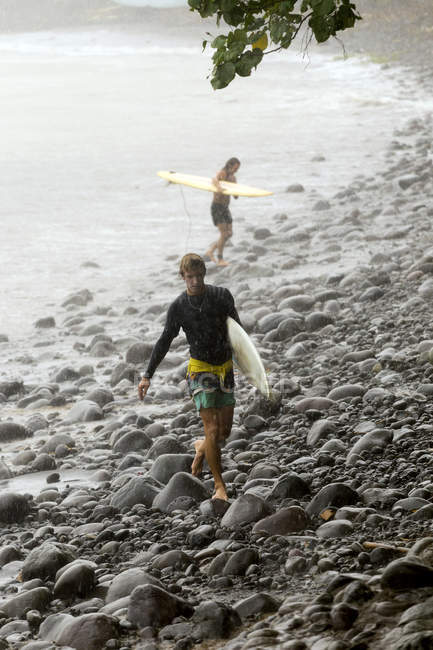 Індонезії Балі, два серферів, несучи дошки для серфінгу в дощ — стокове фото