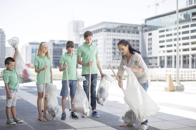 Группа волонтеров, собирающих мусор палками — стоковое фото