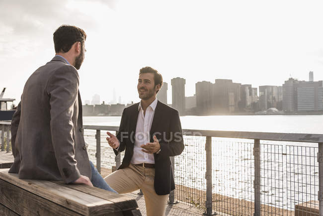 Due uomini d'affari che parlano a East River, New York, USA — Foto stock