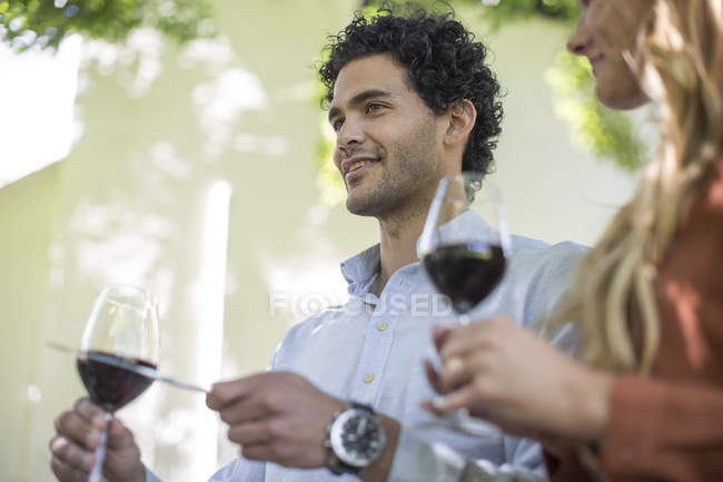 Молодой мужчина с бокалом вина делает объявление — стоковое фото