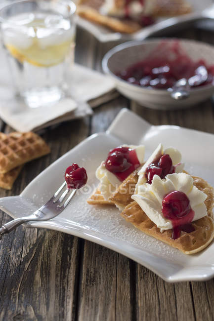 Closeup view of waffles with whipped cream and sour cherries — Stock Photo