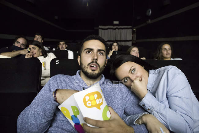 Scared couple watching a movie in a cinema — Stock Photo