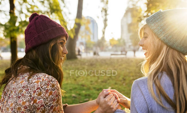 Due migliori amiche che si tengono per mano nel parco in autunno — Foto stock
