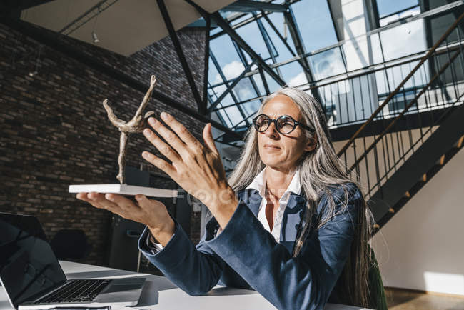 Femme d'affaires regardant la sculpture au bureau dans le bureau — Photo de stock