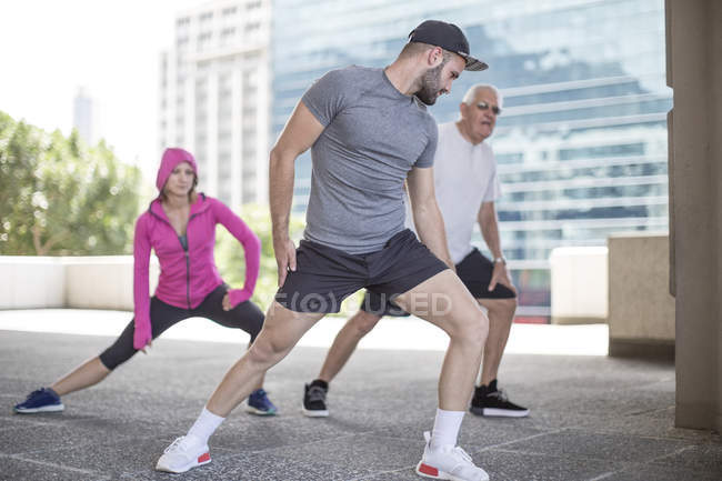 Три спортсмени робить гімнастику у місті — стокове фото