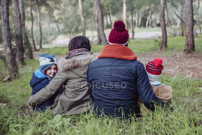 Rear view of family sitting together in forest — Stock Photo