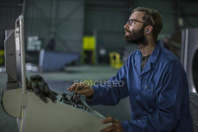Focused worker operating machinery at control panel in tanker factory — Stock Photo