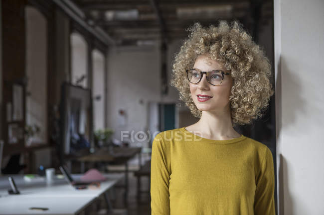 Porträt einer lächelnden Frau, die im Amt seitwärts blickt — Stockfoto