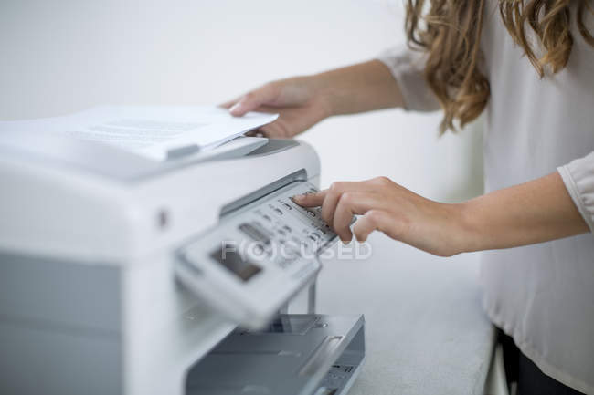 Frauenhände mit Drucker im Büro — Stockfoto